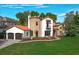 Stunning home featuring a stone turret, red tile roof, and lush, manicured landscaping at 1401 Green Cove Rd, Winter Park, FL 32789