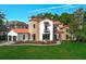 Charming two-story home boasts a stone turret, red tile roof and well-maintained lawn at 1401 Green Cove Rd, Winter Park, FL 32789