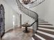 Grand foyer with a curved staircase, dark wrought iron railing, and decorative chandelier at 1401 Green Cove Rd, Winter Park, FL 32789