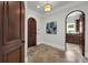 Foyer with an arched doorway leading to the kitchen, tile floor, and traditional wooden door at 1401 Green Cove Rd, Winter Park, FL 32789