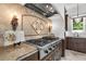 Gourmet kitchen features a professional-grade cooktop, stone backsplash and custom cabinetry at 1401 Green Cove Rd, Winter Park, FL 32789