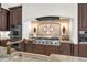 Gourmet kitchen features a pro-grade range, custom tile backsplash, and dark wood cabinetry at 1401 Green Cove Rd, Winter Park, FL 32789