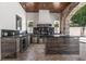 Well-equipped outdoor kitchen featuring wooden ceiling, stone archway, black granite countertops, and stone flooring at 1401 Green Cove Rd, Winter Park, FL 32789