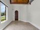 Bright bedroom with a beam ceiling, tiled floor, and a view to the outdoors at 1401 Green Cove Rd, Winter Park, FL 32789
