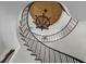 Intricate wrought iron chandelier above a winding staircase with wood steps at 1401 Green Cove Rd, Winter Park, FL 32789