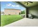 Covered patio features a grill and a large green backyard on a sunny day at 1401 Yellow Finch Dr, Davenport, FL 33837