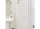 A white pedestal sink with a round mirror and white walls in this well-lit bathroom at 1401 Yellow Finch Dr, Davenport, FL 33837