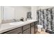 Bathroom featuring double sinks, a shower with tub, gray countertops, and gray wood cabinets at 1401 Yellow Finch Dr, Davenport, FL 33837