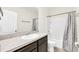 Well-lit bathroom featuring a white vanity, neutral countertop, a large mirror and a shower at 1401 Yellow Finch Dr, Davenport, FL 33837