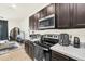 Kitchen featuring stainless steel appliances, dark cabinetry, and a light countertop at 1401 Yellow Finch Dr, Davenport, FL 33837