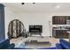 A bright living room with dark wood cabinets, a large screen tv, tile floor and a blue sofa at 1401 Yellow Finch Dr, Davenport, FL 33837