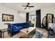 Living room with a blue velvet sofa, modern decor, and a sliding glass door to the outside at 1401 Yellow Finch Dr, Davenport, FL 33837