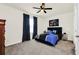 Comfortable main bedroom featuring a ceiling fan, plush carpet, a blue bed and modern decor at 1401 Yellow Finch Dr, Davenport, FL 33837