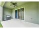 Covered patio features ceiling fan, gray walls, and sliding glass doors to the yard plus a handy barbecue grill at 1401 Yellow Finch Dr, Davenport, FL 33837