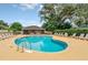 Community pool with lounge chairs, surrounded by mature trees and a screened cabana at 1401 Yellow Finch Dr, Davenport, FL 33837