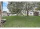 Lush backyard featuring mature shade trees, well-kept lawn, and partial views of neighboring screened in porches at 1455 Blue Horizon Dr, Clermont, FL 34714