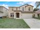 Two-story home featuring a two-car garage, neutral paint, a lawn, and a front door at 1455 Blue Horizon Dr, Clermont, FL 34714