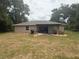 View of the backyard and covered patio with a grill, outdoor furniture, and adjacent lawn at 14598 Se 28Th Ct, Summerfield, FL 34491