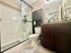 The bathroom features a walk-in shower, a toilet, and a sink with a wooden cabinet at 14598 Se 28Th Ct, Summerfield, FL 34491