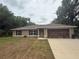 Charming single-story home featuring a well-maintained lawn and a two-car garage at 14598 Se 28Th Ct, Summerfield, FL 34491