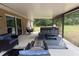 The covered patio includes wicker furniture, a hot tub, and a lovely view of the backyard at 14598 Se 28Th Ct, Summerfield, FL 34491