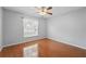 Clean, empty bedroom with wood floors, ceiling fan, and sunny window with coverings at 14848 Bonnybridge Dr, Orlando, FL 32826