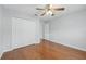 Bright bedroom featuring wood floors, ceiling fan, and a closet with bi-fold doors at 14848 Bonnybridge Dr, Orlando, FL 32826