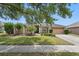 Charming single-story home with lush green lawn, mature trees, and attached two-car garage at 14848 Bonnybridge Dr, Orlando, FL 32826