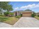 Charming single-story home with a well-manicured lawn, mature landscaping, and a two-car garage at 14848 Bonnybridge Dr, Orlando, FL 32826