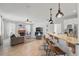 Open-concept living room featuring a fireplace, modern furnishings, and a kitchen bar with pendant lighting at 14848 Bonnybridge Dr, Orlando, FL 32826