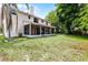Sprawling backyard featuring mature trees, a screened-in porch, and a two-story home exterior at 1802 Imperial Palm Dr, Apopka, FL 32712