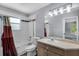 Well-lit bathroom featuring a shower-tub combo, toilet, and sink with storage at 1802 Imperial Palm Dr, Apopka, FL 32712