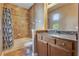 Bathroom with granite vanity, shower with tile surround, and gray patterned shower curtain at 1942 Michael Tiago Cir, Maitland, FL 32751