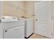 Well-equipped laundry room featuring a white washer and dryer with a wire rack shelf above at 1942 Michael Tiago Cir, Maitland, FL 32751