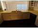 Kitchen sink and countertops with white cabinetry and views to the brick fireplace in the Gathering room at 1985 Japonica Rd, Winter Park, FL 32792