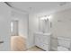 Well-lit bathroom featuring white vanity, toilet, and mirror with a peek into the bedroom at 2213 Grand Cayman Ct # 1138, Kissimmee, FL 34741