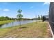 Backyard with a tranquil lake view adjacent to the screened lanai of a home at 2574 Shanti Dr, Kissimmee, FL 34746