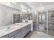 Spacious bathroom with double sinks, a large mirror, and multiple glass-enclosed showers at 2574 Shanti Dr, Kissimmee, FL 34746