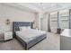 Stylish bedroom features a upholstered bed, decorative lighting, and a dedicated workspace near the windows at 2574 Shanti Dr, Kissimmee, FL 34746