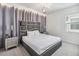 Well-lit bedroom with a decorative headboard, side tables, chandelier, and a large window at 2574 Shanti Dr, Kissimmee, FL 34746