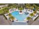Aerial view of a resort-style community pool complete with palm trees, lounge chairs, and play area at 2574 Shanti Dr, Kissimmee, FL 34746