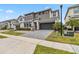 Exterior showcasing a modern home with a two-car garage, gray driveway, landscaping, and two-tone facade at 2574 Shanti Dr, Kissimmee, FL 34746