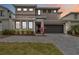 Modern two-story home with a two-car garage, gray driveway, neatly landscaped yard and bushes at 2574 Shanti Dr, Kissimmee, FL 34746