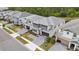 New construction three-story home with a gray driveway, three car garage, and pristine landscaping at 2574 Shanti Dr, Kissimmee, FL 34746