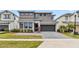 Modern home featuring a two-car garage, gray driveway, and well-maintained landscaping in the front yard at 2574 Shanti Dr, Kissimmee, FL 34746
