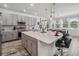 Modern kitchen features gray cabinets, stainless appliances, and a large center island with bar seating at 2574 Shanti Dr, Kissimmee, FL 34746