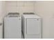 Well-lit laundry room featuring a modern Samsung washer and dryer with a wire rack for added convenience at 2574 Shanti Dr, Kissimmee, FL 34746