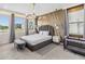 Stylish bedroom with decorative wall, modern lighting fixtures, large windows and a luxurious upholstered bed at 2574 Shanti Dr, Kissimmee, FL 34746