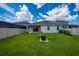 View of the home's spacious backyard with a fire pit, privacy fence, and covered patio at 2591 Seagirt Way, Clermont, FL 34711