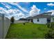 Spacious backyard with well-kept lawn, fire pit, and a white fence at 2591 Seagirt Way, Clermont, FL 34711